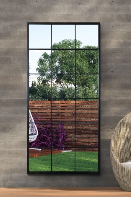 Extra large rectangular grid wall mirror mounted outdoors reflecting a lush garden scene